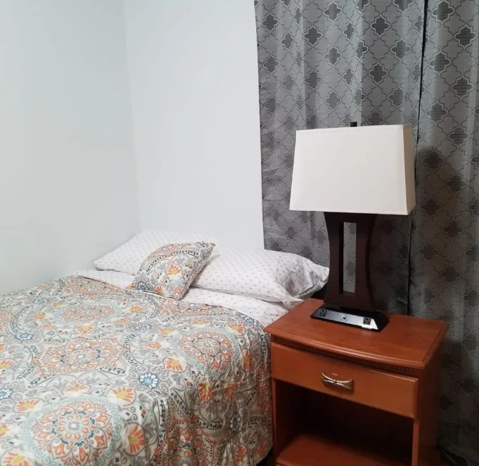 Resident bedroom with bedside lamp at Robinwood House